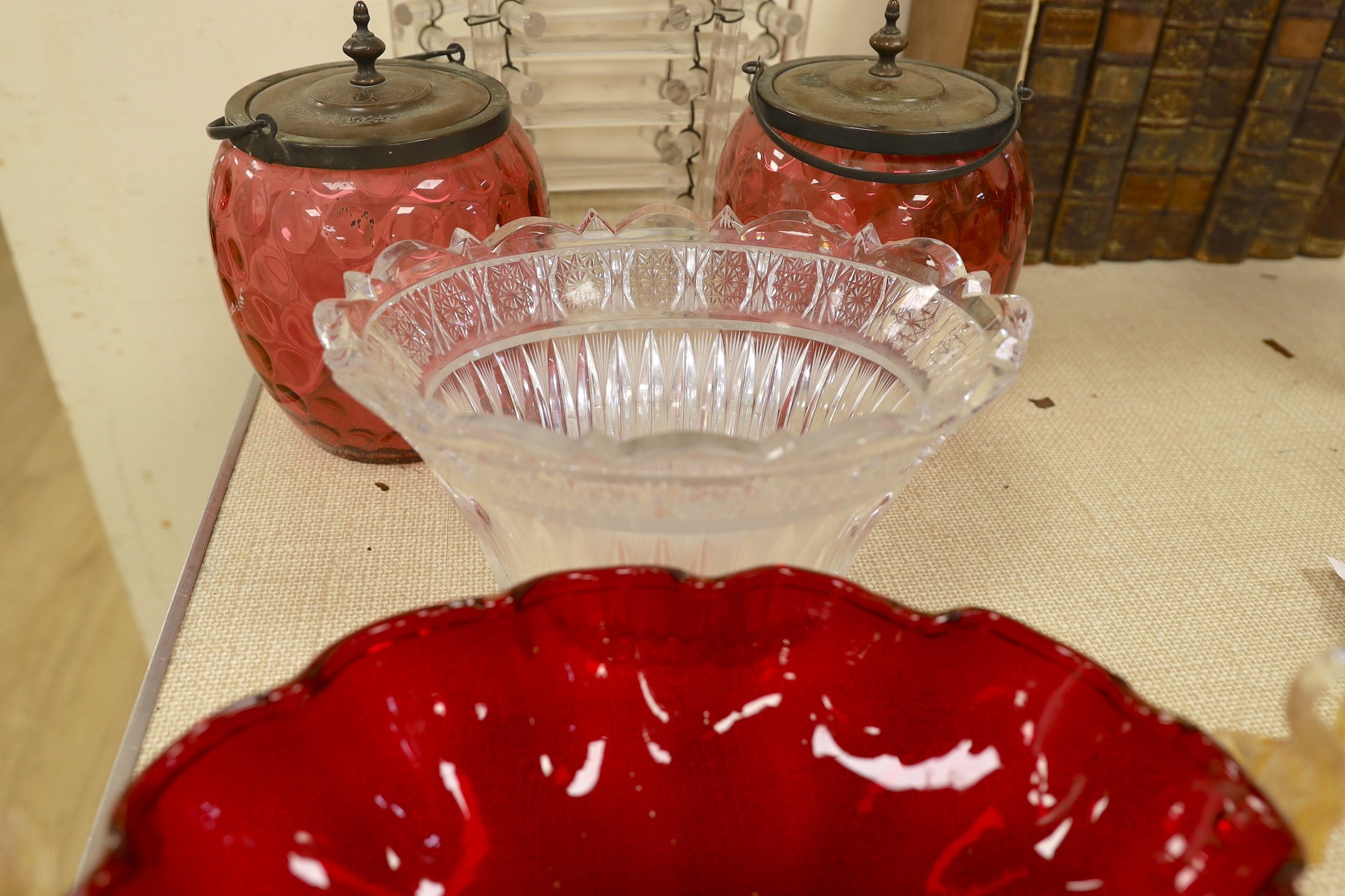 An abstract glass plant pot holder, together with a pair of cranberry glass jars and covers, etc.